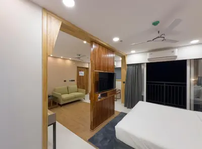 a hotel room with a bed and a television at The Habitat Suites-Walkable distance to Guruvayoor temple in Guruvāyūr