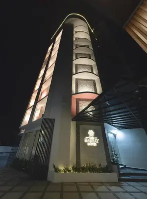 a tall building with a sign on it at night at The Habitat Suites-Walkable distance to Guruvayoor temple in Guruvāyūr