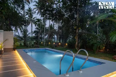 a swimming pool with two metal rails around it at StayVista at Nature Nook with Pvt Pool & Terrace Access in Trichūr