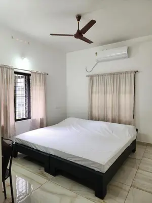 a bedroom with a bed and a ceiling fan at Olive Homestay 1bhk Diamond Ernakulam in Alwaye