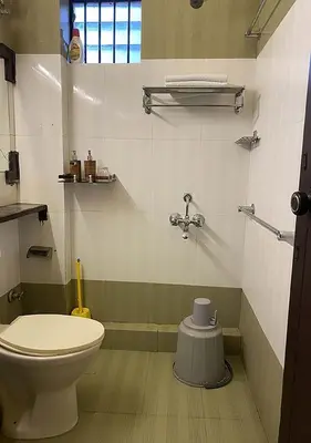 a bathroom with a toilet and a sink at Joys Stay in Trichūr