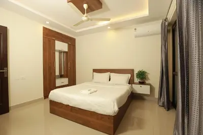 a bedroom with a bed and a ceiling fan at VVP serviceapartments cochin Airport in Nedumbassery