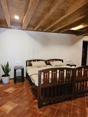 a bedroom with two wooden beds in a room at Moksha The blissful escape in Kaniyāmbetta
