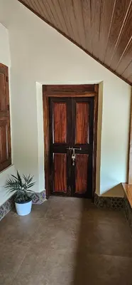 an empty room with a wooden door and a plant at Moksha The blissful escape in Kaniyāmbetta