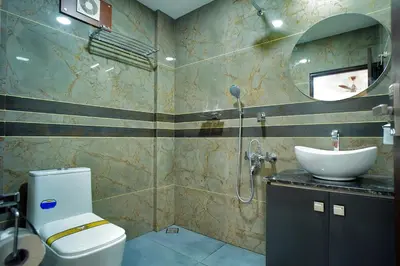 a bathroom with a white toilet and a sink at UNIVERSAL RESIDENCY in Perumbavoor