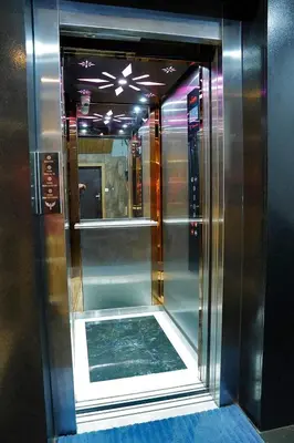 a glass elevator in a room with a mirror at UNIVERSAL RESIDENCY in Perumbavoor
