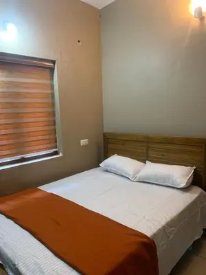 a bed with two pillows and a window in a bedroom at Maskan Home Stay in Kakkadampoyil