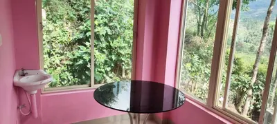a bathroom with a glass table in front of two windows at jacaranda resorts in Kanthalloor