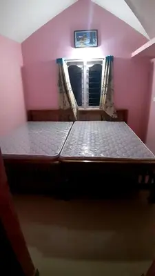 a large bed in a room with a window at jacaranda resorts in Kanthalloor
