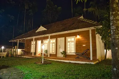 a small house with a porch at night at Village of Blossom in Ernakulam