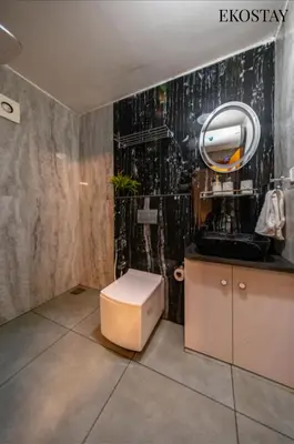 a bathroom with a toilet and a sink at EKOSTAY - Moonlight Villa in Kodaikānāl