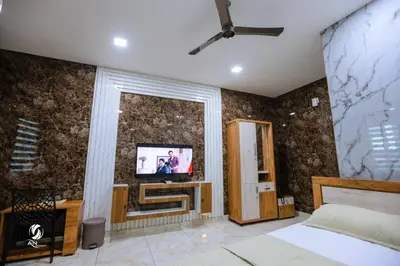 a bedroom with a bed and a tv on the wall at AN REGENCY in Edappāl