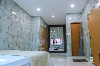 a bedroom with a tv in a stone wall at AN REGENCY in Edappāl