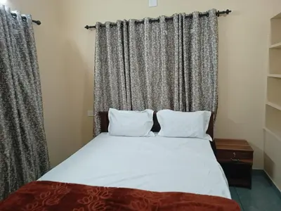 a bed with two pillows in front of a window at Souparnika Lakeview Homestay LLP in Wayanad
