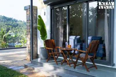two chairs and a table sitting on a patio at StayVista at The Big Chill with Breakfast Included in Wayanad