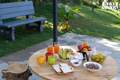 a wooden table with breakfast foods and drinks on it at StayVista at The Big Chill with Breakfast Included in Wayanad