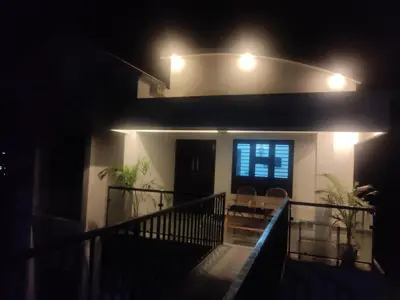 a house at night with lights on a balcony at Mount River Homestay in Palakkad
