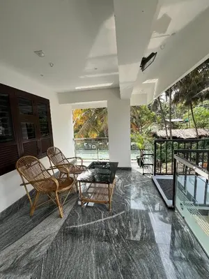 a living room with two chairs and a table at Mount River Homestay in Palakkad