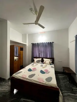 a bedroom with a large bed with a ceiling fan at Mount River Homestay in Palakkad