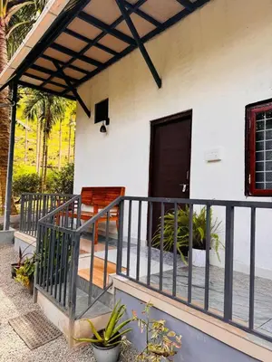 a porch of a house with a fence at Mount River Homestay in Palakkad