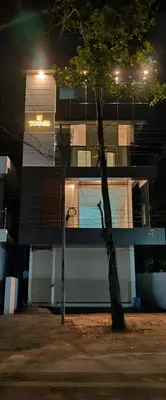 a tree in front of a building at night at Spacious 2BHK Near Airport in Cochin