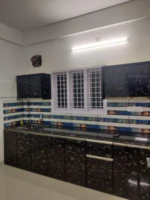 a kitchen with black cabinets and blue and white stripes at Spacious 2BHK Near Airport in Cochin