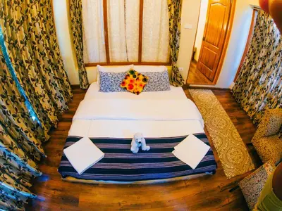 a bedroom with a bed with a stuffed animal on it at LA Address Retreat - The Heritage Homestay in Ooty