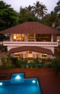 a house with a swimming pool in front of it at Kappad Beach House by Kisah Stays in Kappad