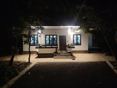 a house at night with lights on the front at Woodside Haven in Chekadi