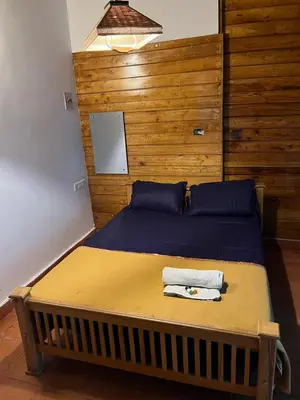 a bedroom with a bed with a wooden wall at Royal Wooden villa in Mananthavady
