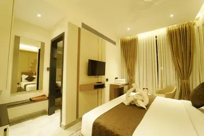 a hotel room with a bed with a stuffed animal on it at Yuvraj Le: Royale in Mysore