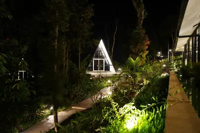 a small greenhouse in a garden at night at Inika in Ponnampet