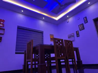 a dining room with a table and two chairs at Happy Villa Homestay in Chelakara
