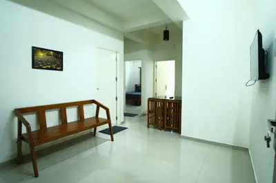 a living room with a bench and a television at Greens in Kozhikode