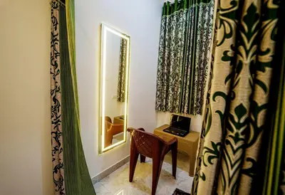 a room with a mirror and a chair and a desk at ARUL Residency in Mettuppālaiyam