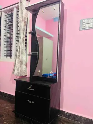 a black dresser with a mirror on a pink wall at Dreamy bungalow 2BHK apartment in Mysore