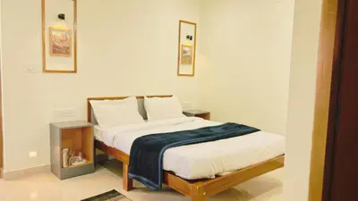 a bedroom with a bed with a blue blanket on it at Hidden doors in Ooty