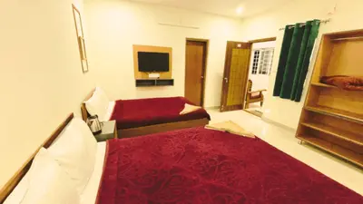 a room with two beds and a television in it at Hidden doors in Ooty
