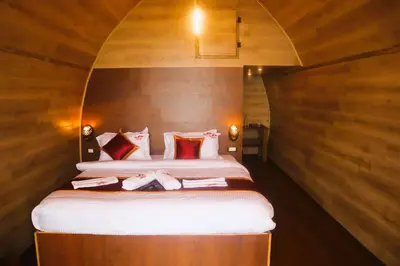 a bedroom with a large bed with wooden walls at Royal Adventures in Kodaikānāl