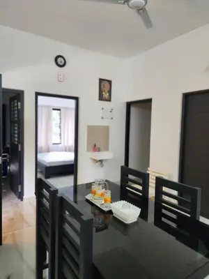 a dining room with a black table and chairs at Olive Home stay Gold 1bhk in Alwaye