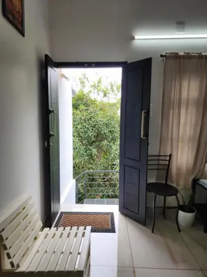 a door to a room with a bench and a table at Olive Home stay Gold 1bhk in Alwaye