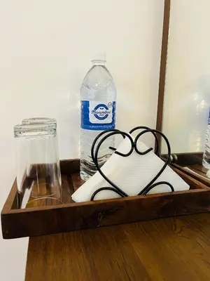 a wooden tray with a bottle of water and a book at Windgram Homestay in Ambalavayal