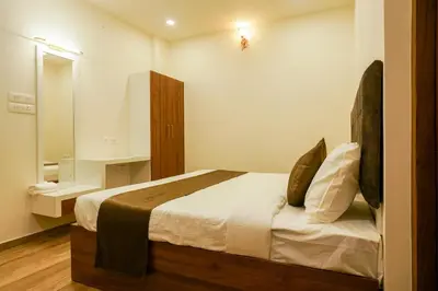 a bedroom with a large bed and a mirror at Grand Plaza Inn in Kottakkal