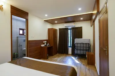 a hotel room with a bed and a bathroom at Grand Plaza Inn in Kottakkal