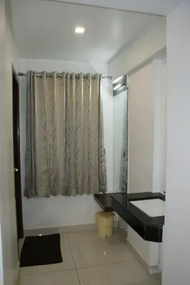 a bathroom with a sink and a shower with a window at Sri Ranga Nivas in Palani