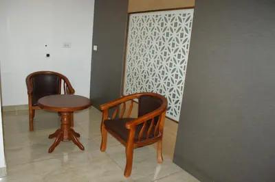 a room with two chairs and a table and a wall at Sri Ranga Nivas in Palani