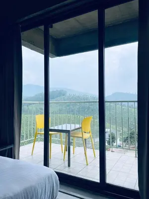 a bedroom with a bed and a table and chairs on a balcony at BEL VISTO in Vālpārai