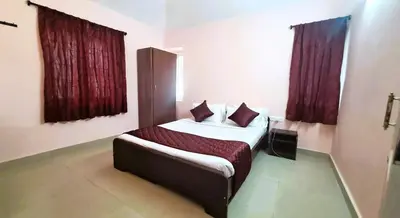a bedroom with a bed with red curtains at iSTAYS - Kodai Villa in Kodaikānāl
