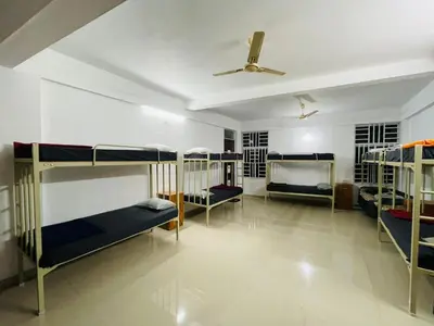 a room with three bunk beds and a ceiling at Queen C Inn Wayanad in Mānantoddy