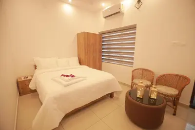 a bedroom with a bed with white sheets and flowers on it at Humblebee Retreat Tattekkad in Kuttampuzha